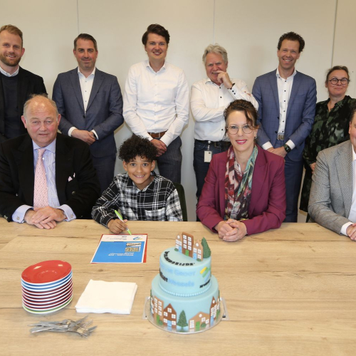 Groepsfoto van mensen achter een tafel met taart