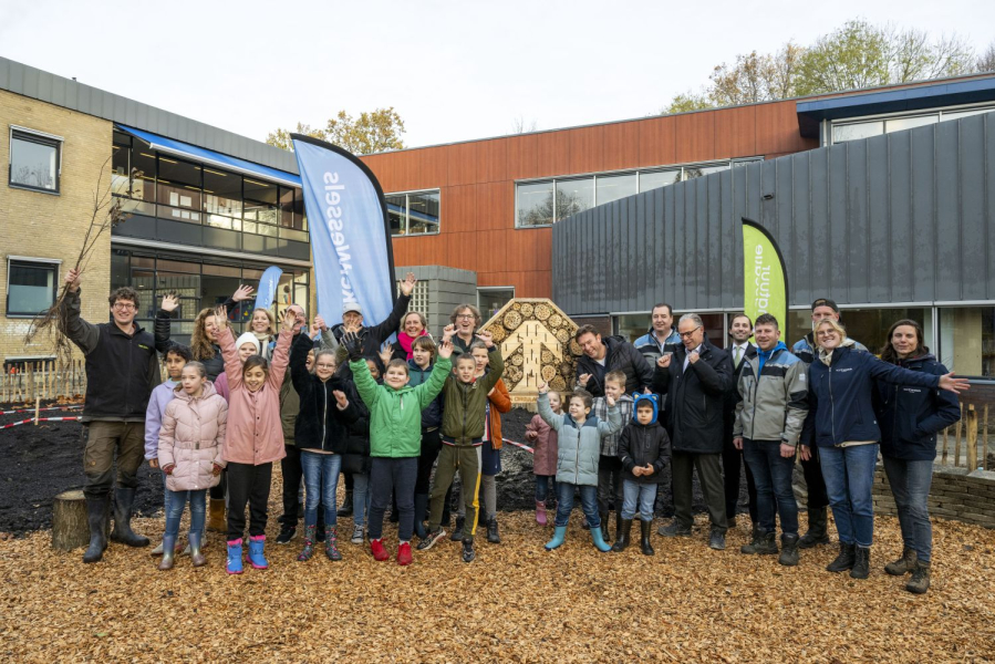 Groepsfoto van het tiny-forest project met volwassenen en kinderen