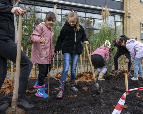 Kinderen die een schep vasthouden op een stuk aarde